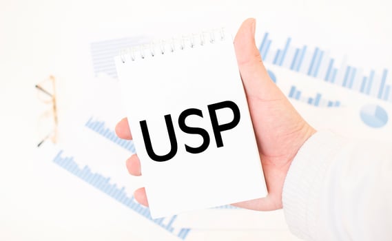 Businessman holding a white notepad with text USP, business concept photo