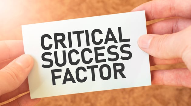 CRITICAL SUCCESS FACTOR word inscription on white card paper sheet in hands of a businessman. recap concept. red and white paper photo