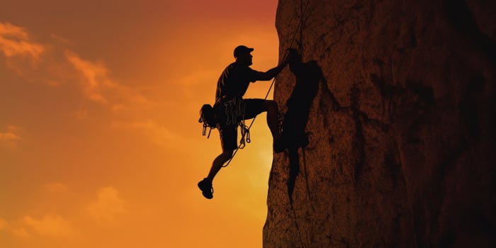 Man rock climbing silhouette blurred background, photo