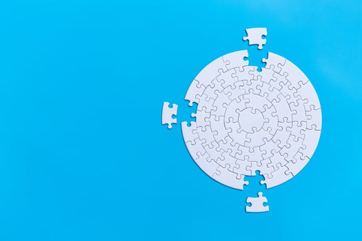 Unfinished white jigsaw puzzle pieces on blue background,  Copy space. photo