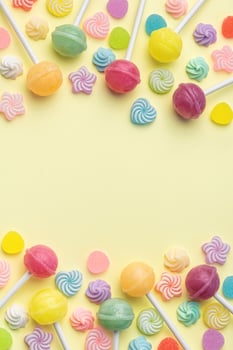 Sweet lollipops and candies on yellow background photo