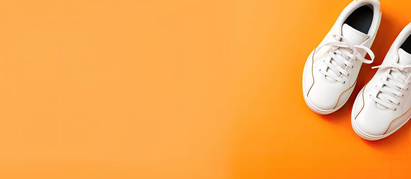 A pair of white tennis shoes on an orange background created with technology photo