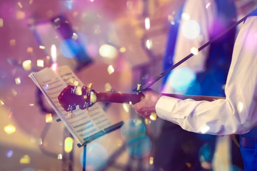 Musical event. Hands of a musician with a guitar in front of a nom in bright confetti. photo