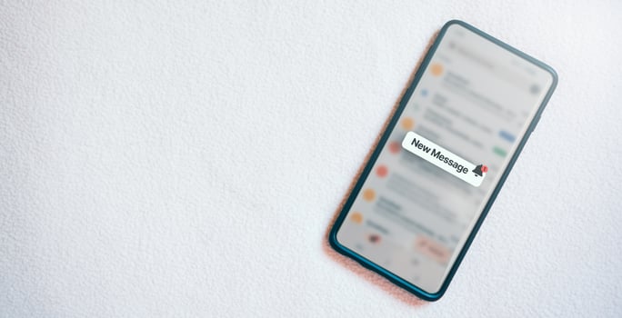 Banner of a smartphone with a new message notification on screen and white texture background. Communication business technology. Inbox view. New e-mail on mobile smartphone. photo