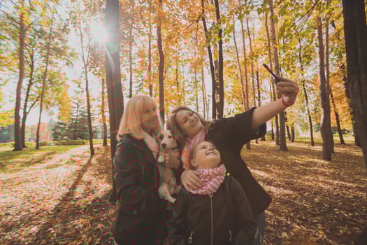 Three generations of women and dog feel fun look at camera posing for self-portrait picture together, funny excited child, mom and grandmother have fun enjoy weekend take selfie on gadget in autumn photo