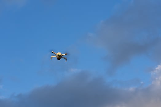 Small Drone Flying Above Blue Sky photo