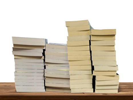 Stack of books lies on wooden table isolated on white background. photo