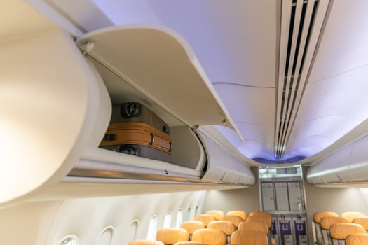 In flight carry on bag cabinet, on board suitcase storage overhead bin in passenger cabin crew. photo