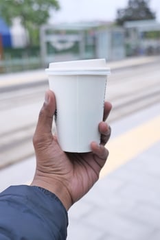 hand holding a take away kraft coffee cup photo
