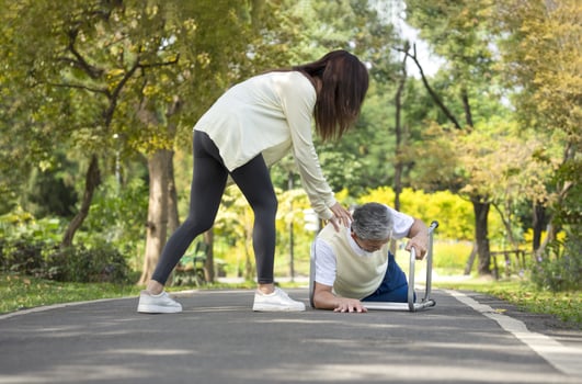 young woman caregiver is helping disability senior man fall due to practice walking with a walker.concept elderly care, health care, rehabilitation photo