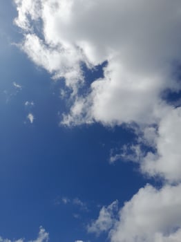 White clouds in the blue sky. Beautiful bright blue background. Light cloudy, good weather. Curly clouds on a sunny day. photo