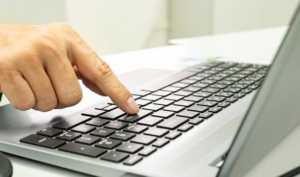 Close up of Human finger pressing enter key on laptop keyboard confirming computer system operation process, Business and technology for your life concept photo