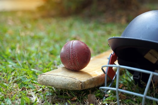 Cricket equipment is a cricket ball, cricket bat, cricket helmet on a grass background. Soft and selective focus. photo