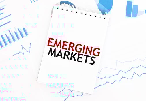 White notepad with text EMERGING MARKETS on the financial documentation. Finance and business concept photo