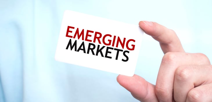 Man in blue sweatshirt holding a card with text EMERGING MARKETS, business concept photo