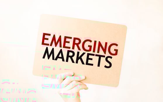 Closeup Business man hand holding show blank paper sheet mock up empty white board space for shouting text rule or protest word. Text EMERGING MARKETS photo