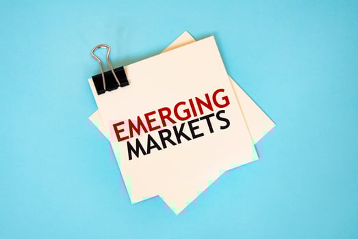 Text EMERGING MARKETS on sticky notes with copy space and paper clip isolated on red background.Finance and economics concept. photo