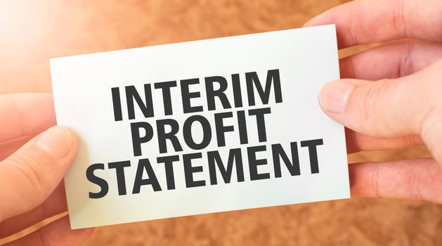 INTERIM PROFIT STATEMENT word inscription on white card paper sheet in hands of a businessman. recap concept. red and white paper photo