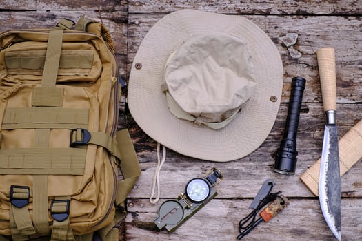 Knife backpack with equipment for survival in the forest on the old wooden background photo