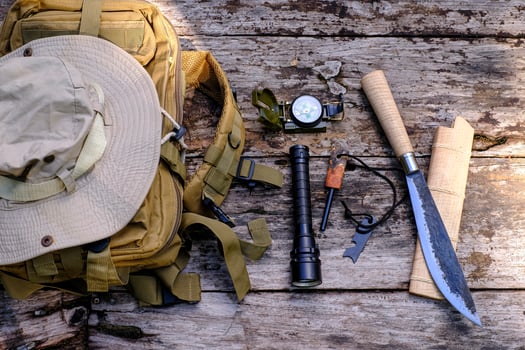 Knife backpack with equipment for survival in the forest on the old wooden background photo