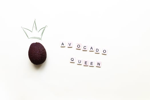 Avocado queen. A crown painted on a photo of an avocado. Flat lay lettering avocado queen