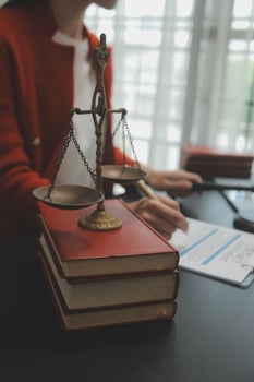 Business and lawyers discussing contract papers with brass scale on desk in office. Law, legal services, advice, justice and law concept picture with film grain effect photo