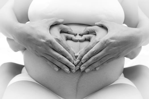 Big United Family Love and Child Birth Concept. Pregnant Belly with Parents and Kids Hands. Father Heart shaped Hands and little Children touching Mother Pregnancy Abdomen. photo