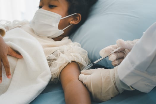 Asian doctor user syringe needle for injection vaccinate,  African American children are being covid vaccinated for prevention coronavirus and flu. Concept of immunization from inoculation photo