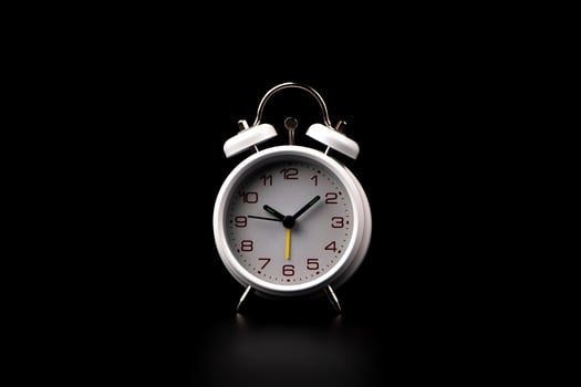 White alarm clock on black background. photo