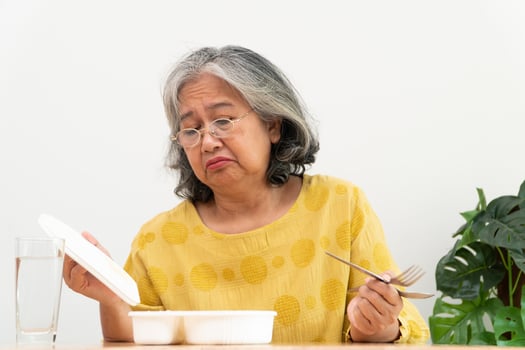 Unhappy Asian senior woman anorexia and say no to ready meals, Elderly home alone and bored food and no appetite photo
