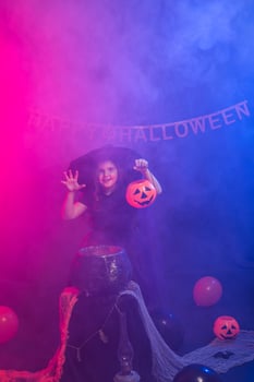 Funny child girl in witch costume for Halloween with pumpkin Jack. photo