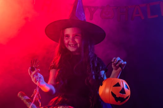 Little witch child cooking potion in the cauldron on Halloween. photo