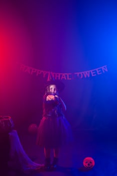 Little girl holds broom on Halloween holiday. Kid girl wear witch costume. Fantasy, fairy tale and masquerade concept. photo