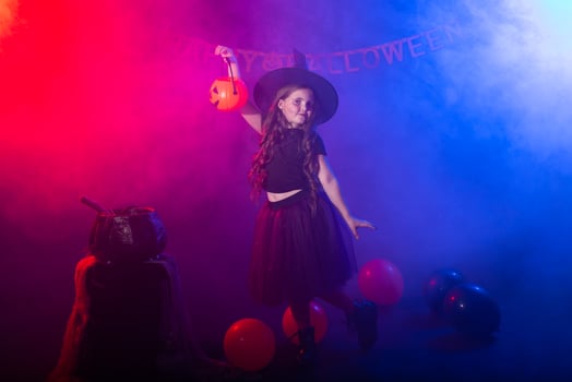 Funny child girl in witch costume for Halloween with pumpkin Jack. photo