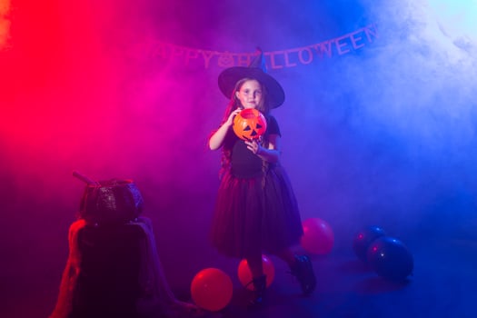 Funny child girl in witch costume for Halloween with pumpkin Jack. photo