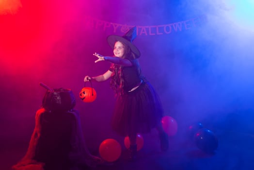 Funny child girl in witch costume for Halloween with pumpkin Jack. photo
