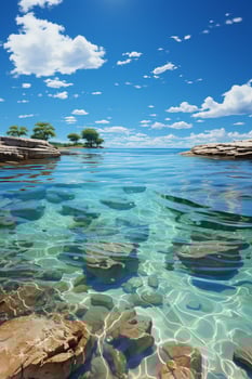 green ocean with gentle waves, sandy seashore, fluffy white clouds in bright blue sky. photo