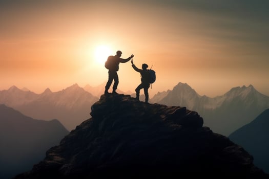 Silhouette of two men with backpacks on the top of the mountain. photo