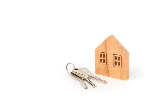 Wooden house model with keys on white background photo