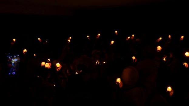 Candles glowing against dark background closeup photo