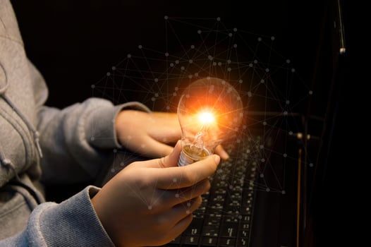 Close up of the hand of a person holding a bright light bulb in black background. Idea, innovation, idea and inspiration for business concept. cyber digital data concept photo