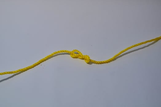 Yellow ropes with knot isolated on white background photo