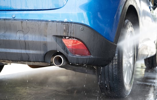 Car washing with high pressure water spray. Car cleaning. Auto care service concept. Vehicle cleaning. High pressure water spraying on car wheel and tyre. Manual car wash with high pressure water. photo