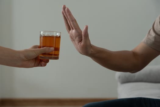 man refuses say no and avoid to drink an alcohol whiskey , stopping hand sign male, alcoholism treatment, alcohol addiction, quit booze, Stop Drinking Alcohol. Refuse Glass liquor, unhealthy, reject photo