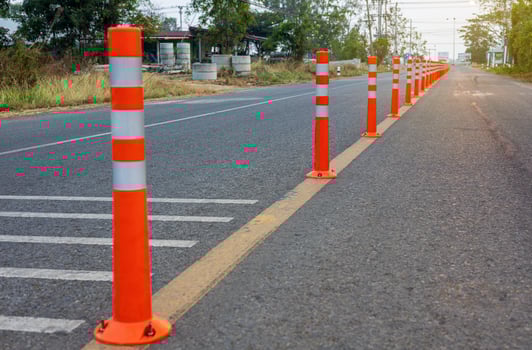 A low-angle view of many reflective orange plastic poles set up as a sign to prevent oncoming traffic. photo