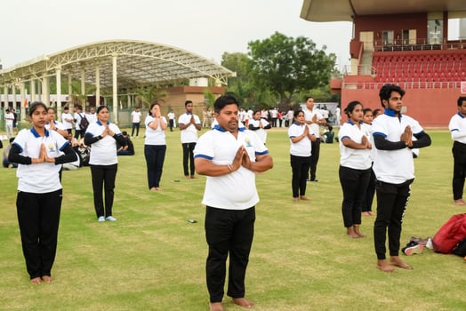 New Delhi, India, June 21, 2023 - Group Yoga exercise session for people at Yamuna Sports Complex in Delhi on International Yoga Day, Big group of adults attending yoga class in cricket stadium photo