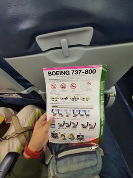 Bangkok, Thailand on May 21, 2023. A hand is holding a safety instruction sheet for a Boeing 737-800 aircraft photo