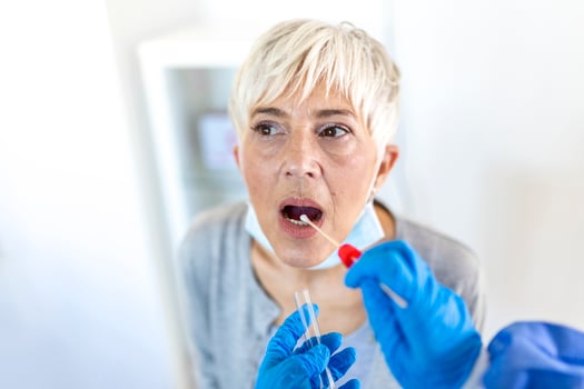 Physician wearing personal protective equipment performing a Coronavirus COVID-19 PCR test, patient nasal NP and oral OP swab sample specimen collection process, viral rt-PCR DNA diagnostic procedure photo