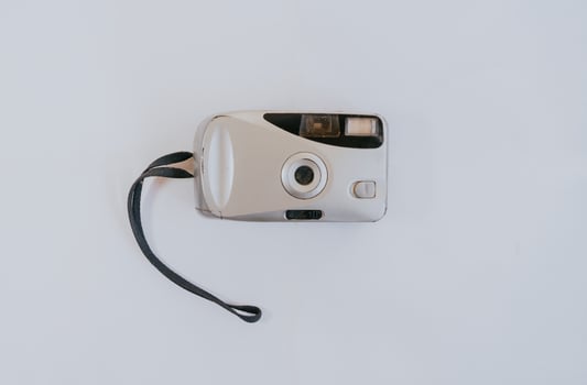 Silver color pocket camera with white background. photo