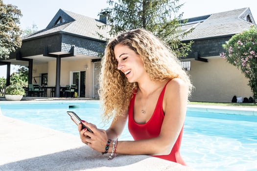 woman in a red swimsuit inside a pool using her cell phone photo
